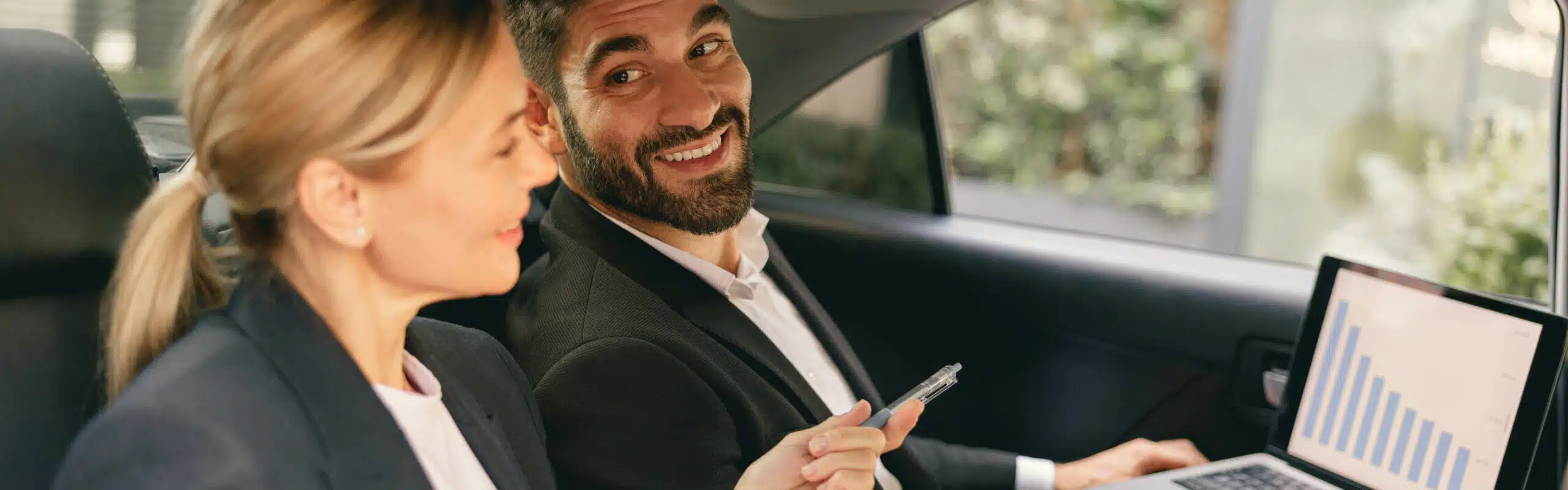 business colleagues working laptop while sitting car backseats way office scaled