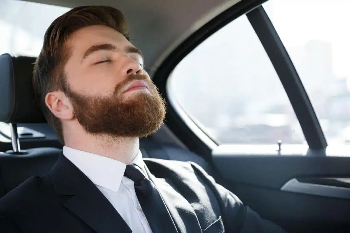 business man sleeping back seat car