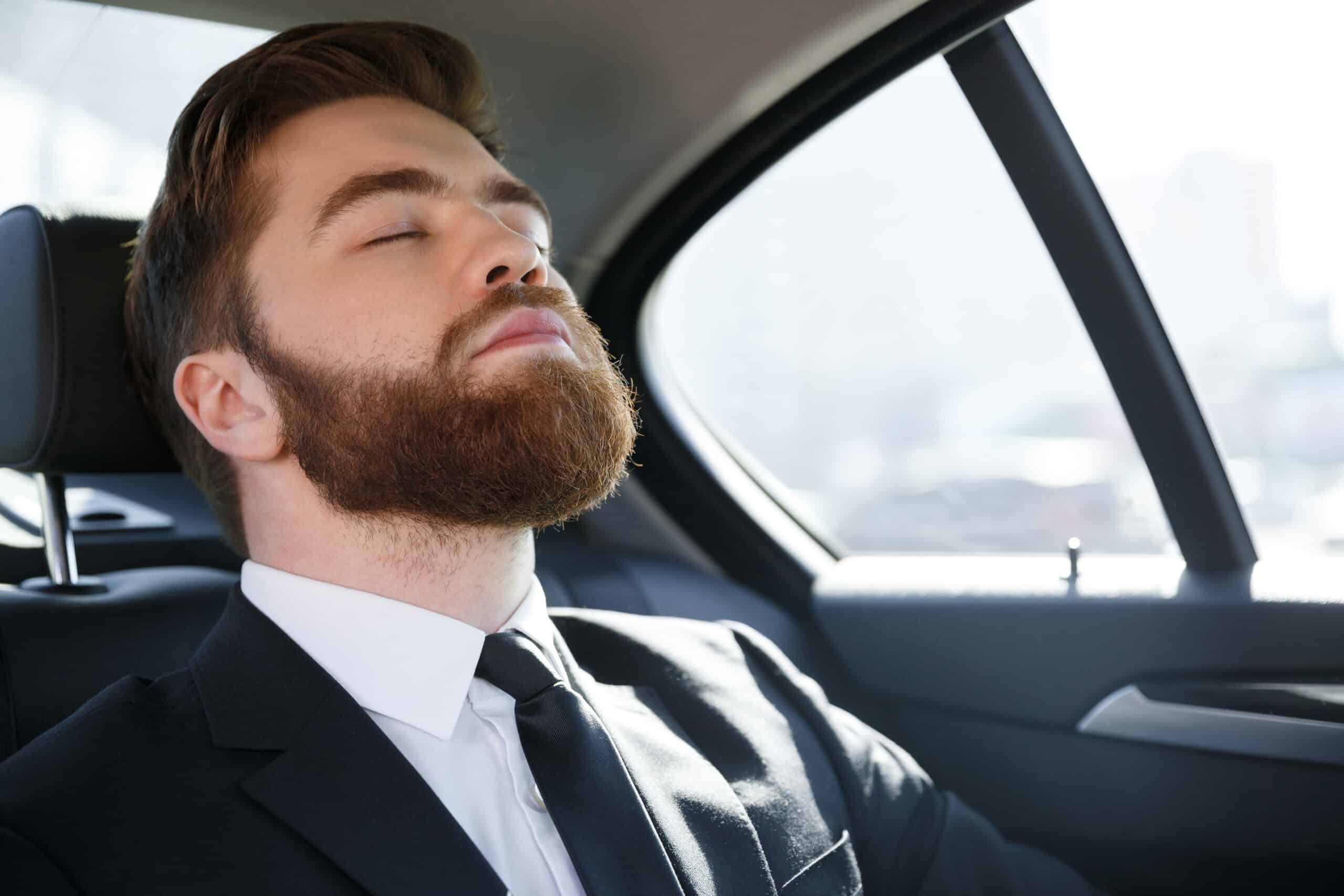 Les erreurs les plus courantes en matière de voyages d'affaires et comment les éviter L'homme qui dort sur la banquette arrière d'une voiture